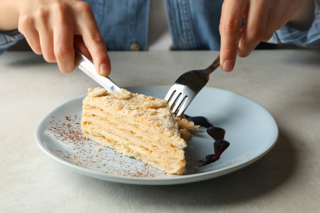 Mulher comendo bolo delicioso de napoleão