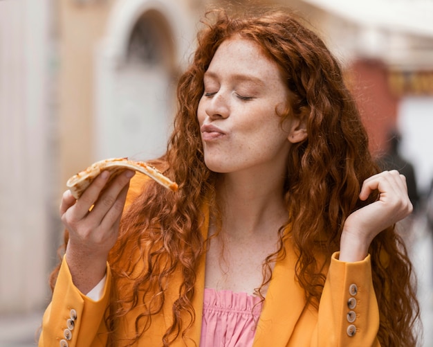 Foto mulher comendo comida de rua ao ar livre