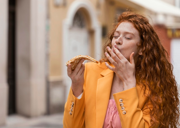 Foto mulher comendo comida de rua ao ar livre