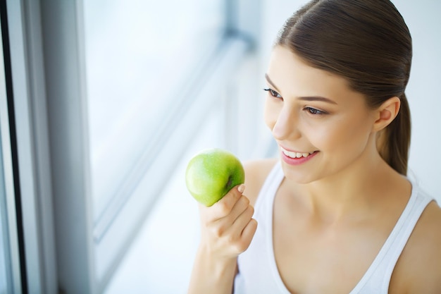 Mulher comendo maçã linda garota com dentes brancos mordendo maçã imagem de alta resolução