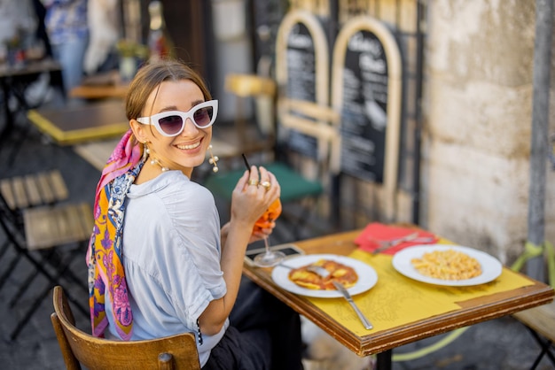 Foto mulher comendo macarrão italiano no restaurante na rua em roma