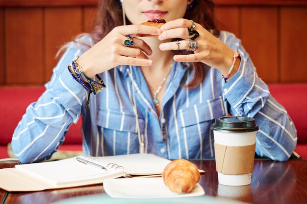 Mulher comendo pastéis com café