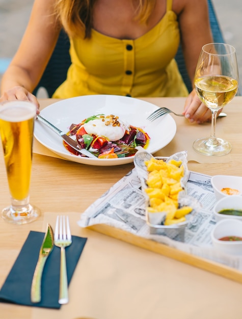 Foto mulher comendo salada saudável com queijo burrata, salada de rúcula e beterraba