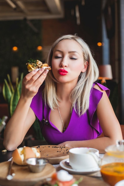 Mulher comendo smorrebrod dinamarquês no restaurante