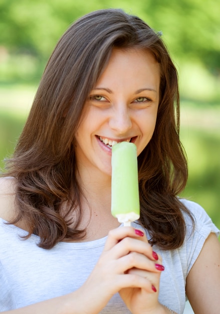 Foto mulher comendo sorvete dia ensolarado ao ar livre