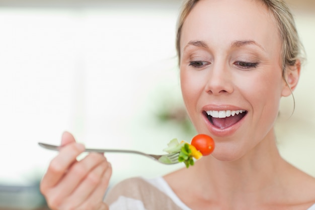 Mulher comendo um tomate