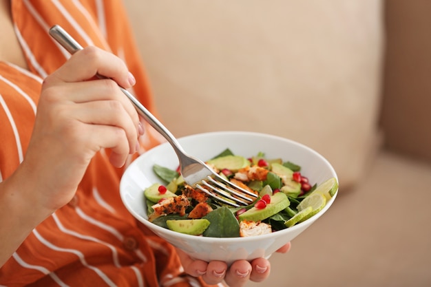 Mulher comendo uma saborosa salada de frango, closeup