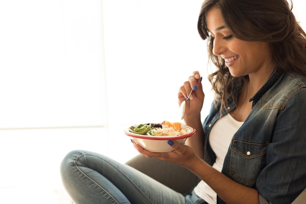Foto mulher comendo uma tigela vegana de superalimentos