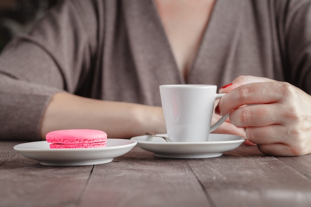 Mulher comer biscoitos de biscoito e beber café