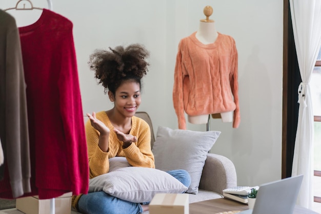 Foto mulher comerciante de moda afro-americana apresentando e vendendo roupas on-line em transmissão ao vivo