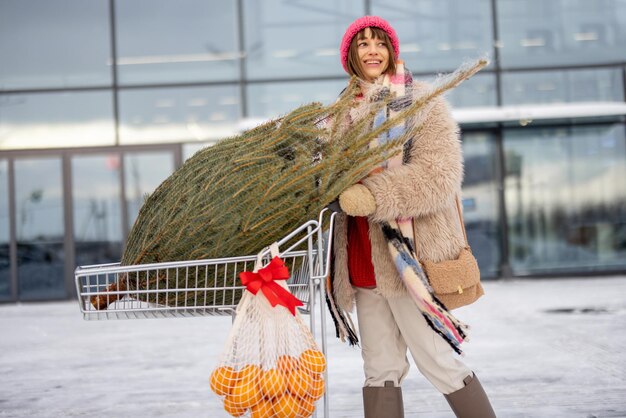 Mulher compra árvore de natal e frutas no shopping