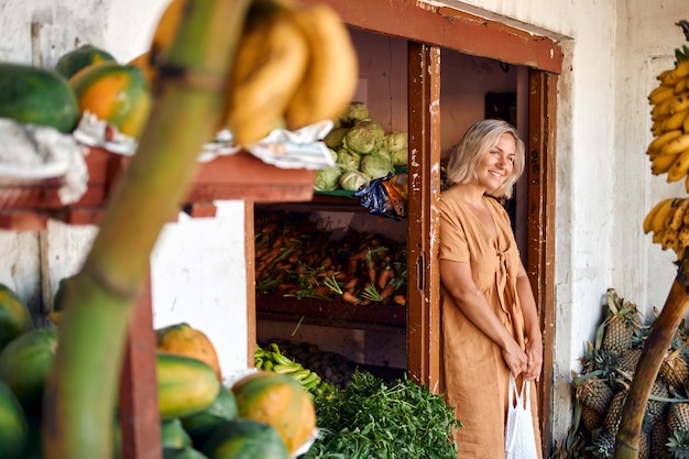 Mulher compra mamão fresco no mercado local Tropical