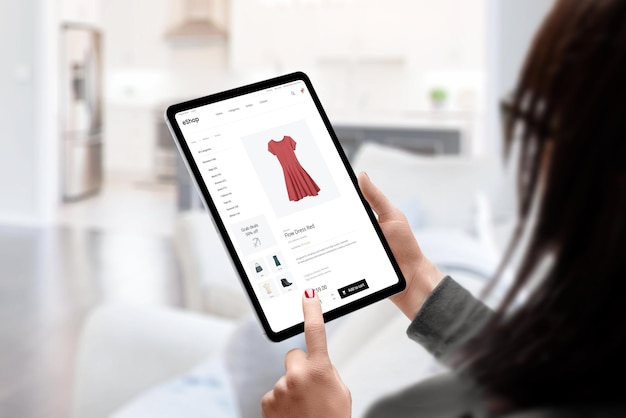 Mulher compra um vestido online com conceito de tablet Site de roupas de comércio eletrônico moderno Sala de estar em segundo plano