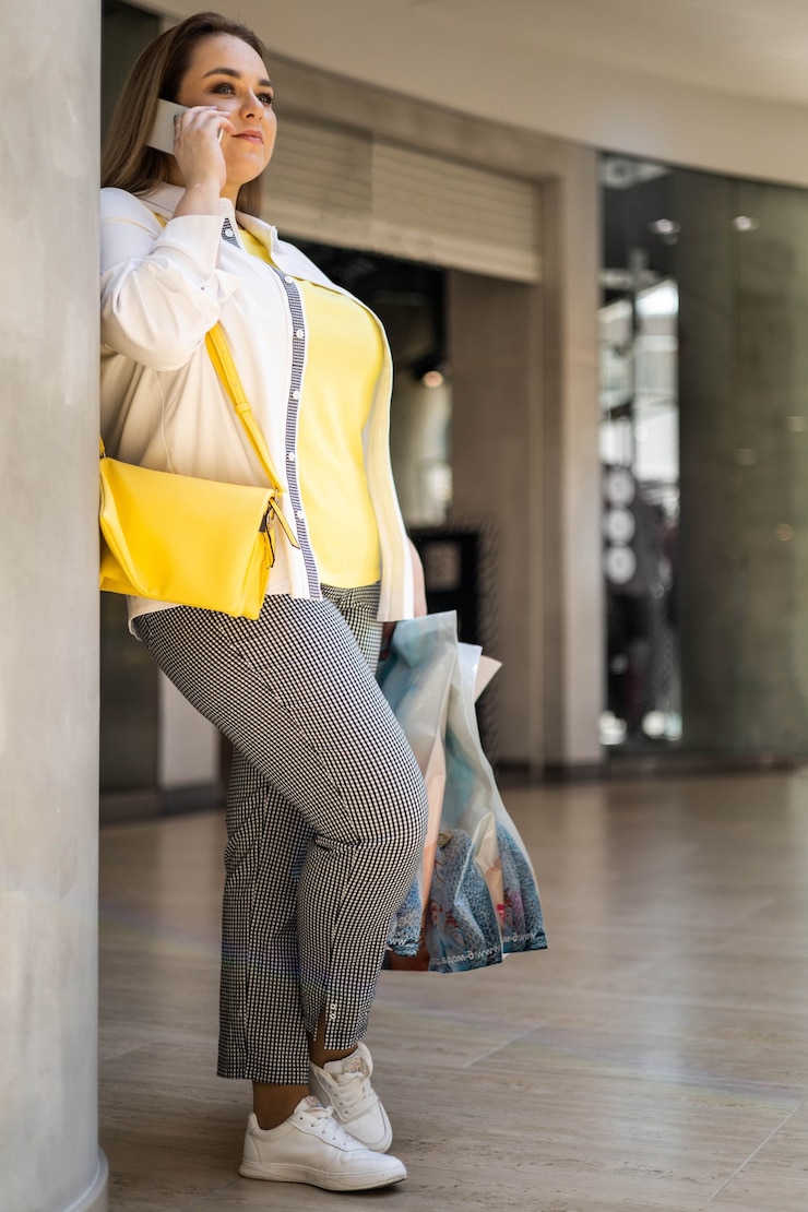 Foto mulher compradora closeup falando smartphone sorrindo segurando sacolas com compras no shopping