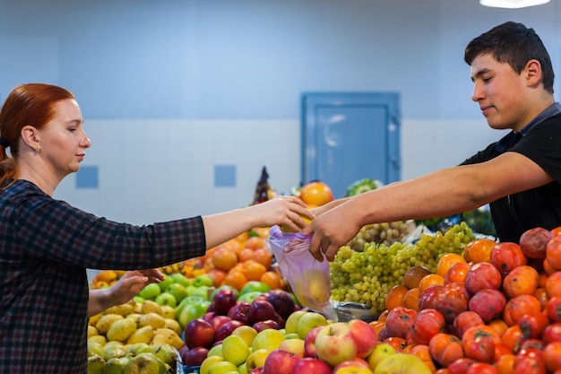 Mulher comprando legumes frescos no mercado de rua