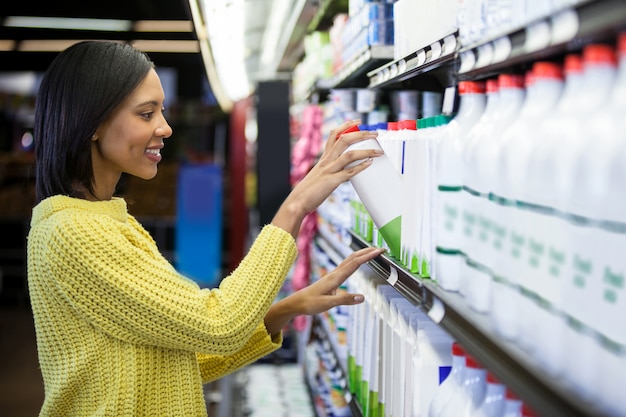 Mulher comprando leite da seção de laticínios