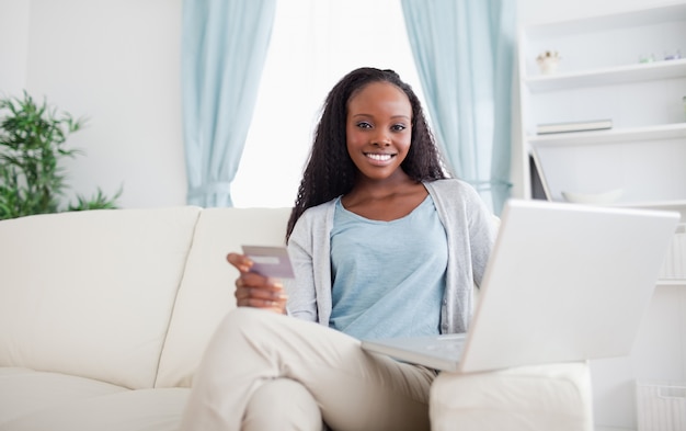 Mulher comprando online enquanto está sentada no chouch