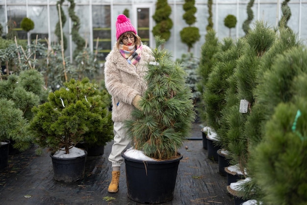 Mulher comprando plantas no mercado ao ar livre durante o inverno