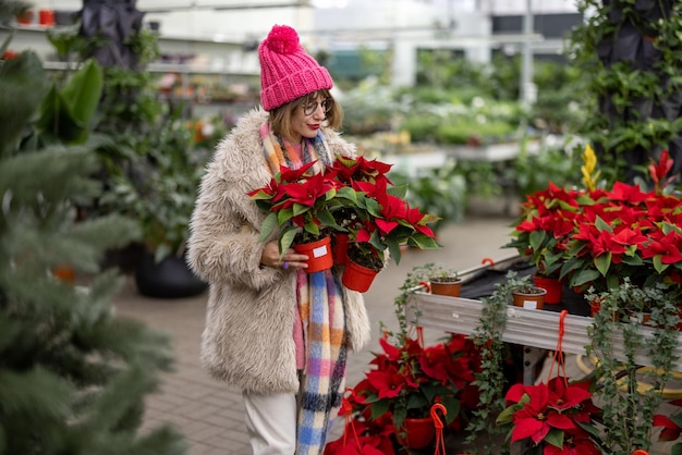 Mulher comprando plantas no mercado ao ar livre durante o inverno