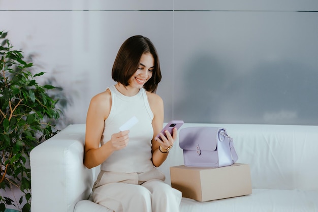 Mulher comprando produtos on-line com um cartão nas mãos