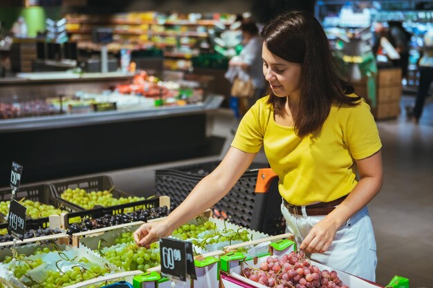 Mulher comprando uvas na loja