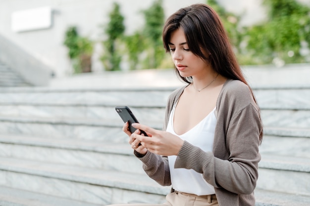 Mulher concentrada olhando para o celular