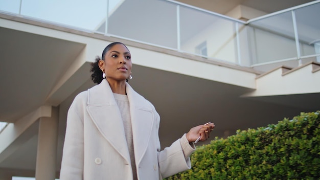Mulher confiante a caminhar pelas ruas dos subúrbios, linda agente imobiliária afro-americana.