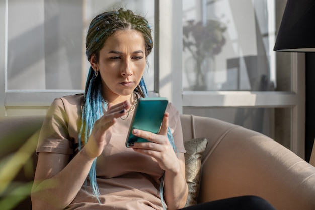 Mulher confiante e hipster conversando, surfando na internet, usando smartphone, digitando mensagem aplicativo móvel