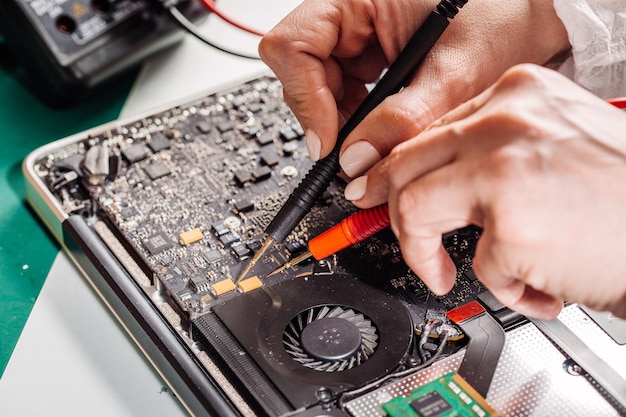 Mulher consertando laptop no centro de serviço Reparando e consertando serviço no laboratório Conceito de serviço de reparo eletrônico