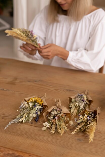 Foto mulher construindo seu próprio arranjo de flores secas