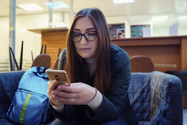 Mulher conversa com amigos usando smartphone e sorri