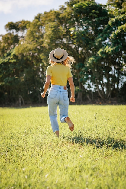 Mulher correndo no campo. Foto vertical