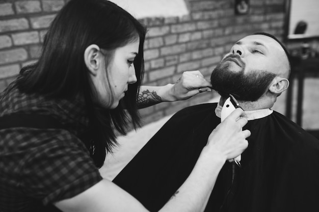 Mulher cortando a barba do homem