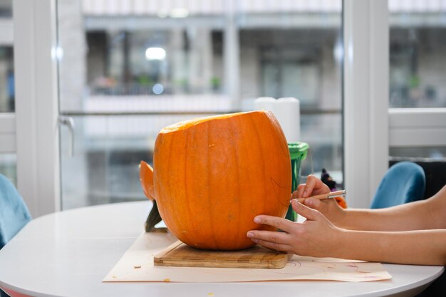 Mulher cortando abóbora para o Halloween