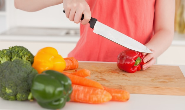 Mulher cortando alguns vegetais na cozinha