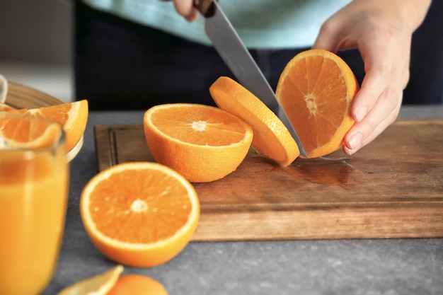 Foto mulher cortando laranja a bordo na cozinha