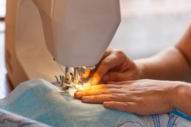 Mulher costura em uma máquina de costura