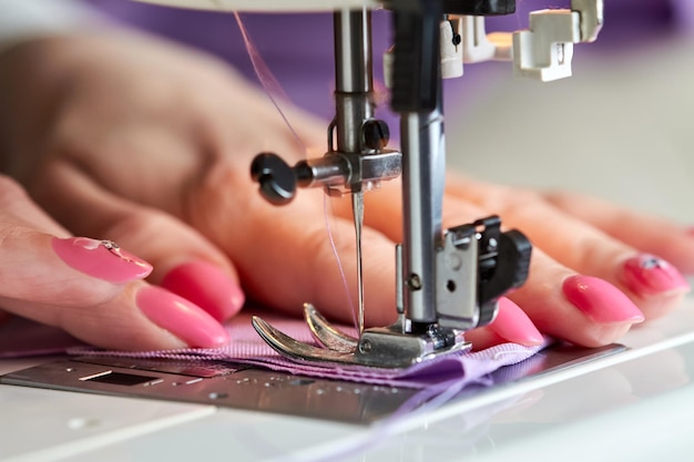 Mulher costurando um vestido em uma máquina de costura
