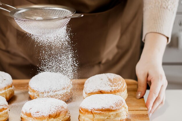 Foto mulher cozinhando donuts.