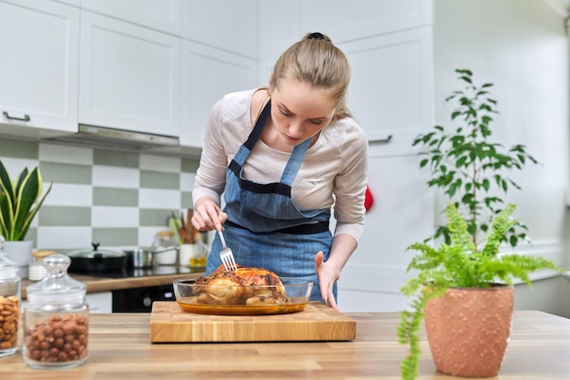 Mulher cozinhando frango assado em casa na cozinha