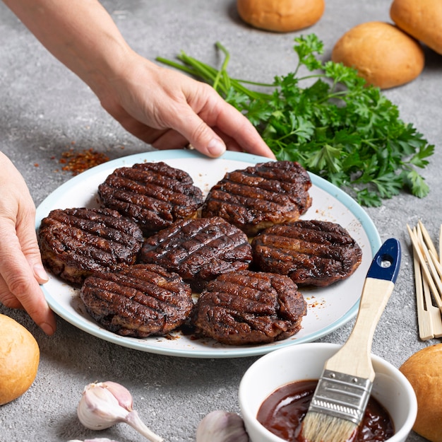 Mulher cozinhando hambúrguer de carne em casa na cozinha