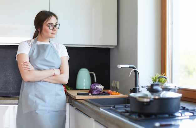 Mulher cozinhando na nova cozinha fazendo comida saudável com legumes