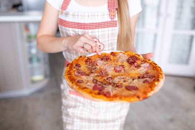 Mulher cozinhando pizza em casa