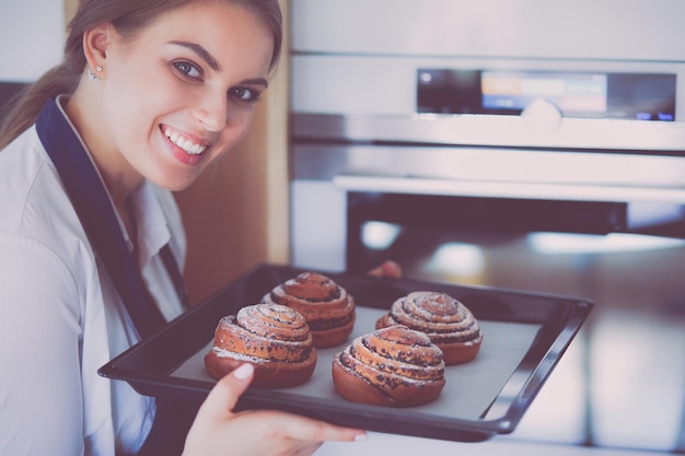 Mulher cozinheira segurando o prato com assados caseiros