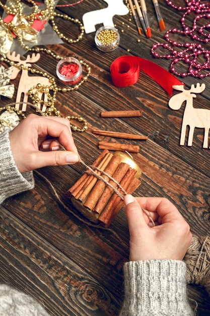 Mulher cria presentes de Natal elegantes, decore uma vela com canela