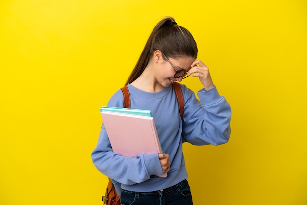 Mulher criança estudante sobre uma superfície amarela isolada rindo