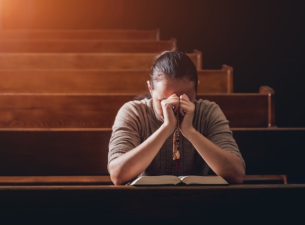 Foto mulher cristã orando na igreja.