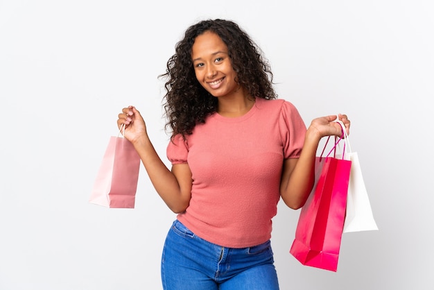 Mulher cubana isolada no branco segurando sacolas de compras e sorrindo