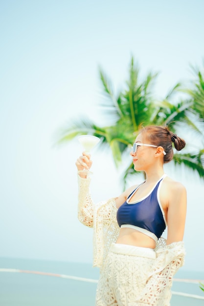 Foto mulher curtindo praia relaxando alegre no verão garota de férias usando óculos de sol