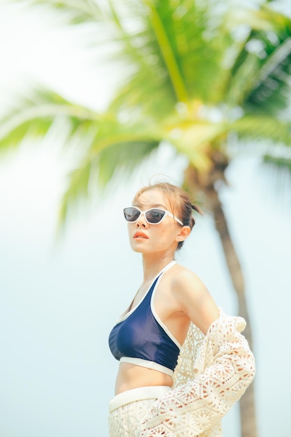 Foto mulher curtindo praia relaxando alegre no verão garota de férias usando óculos de sol